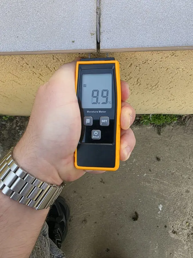 Umidometru ținut pe un parapet, sub un rost