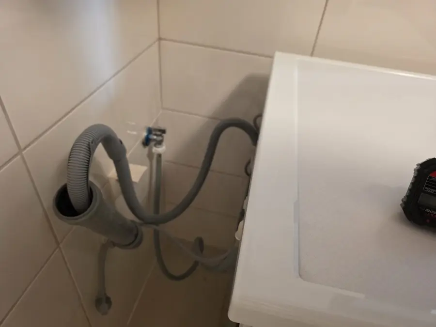 Furtunul unei mașini de spălat introdus într-o țeavă de canalizare