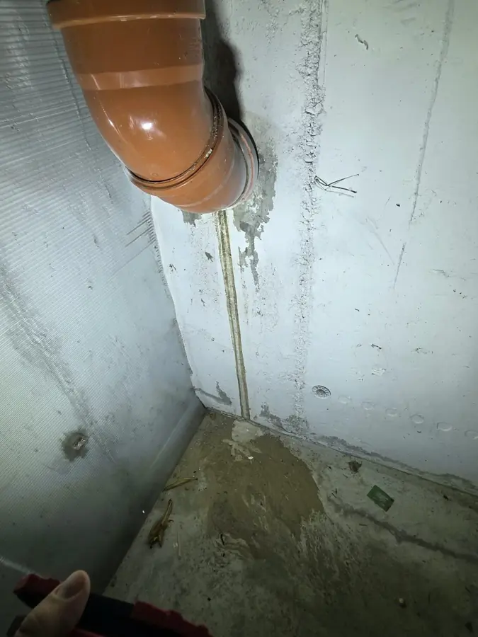 Nisip fin depus la baza unui perete, pe traseul unei dungi de scurgere